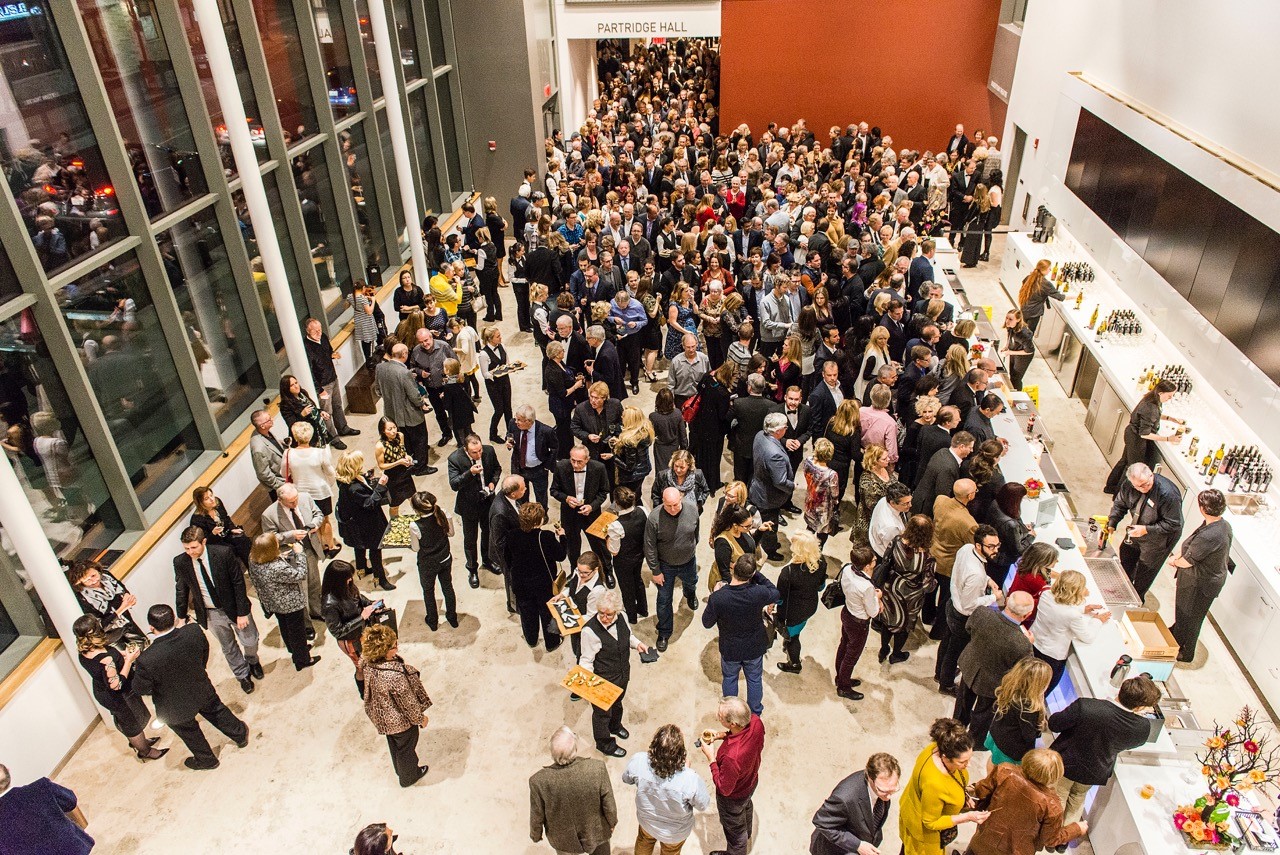 Crowded lobby with patrons coming in and out of the theatre.