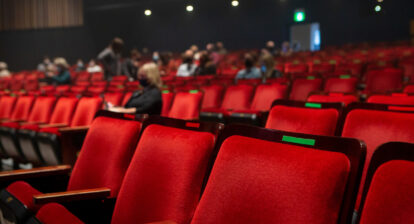 A nearly empty theatre, with seats marked for social distancing