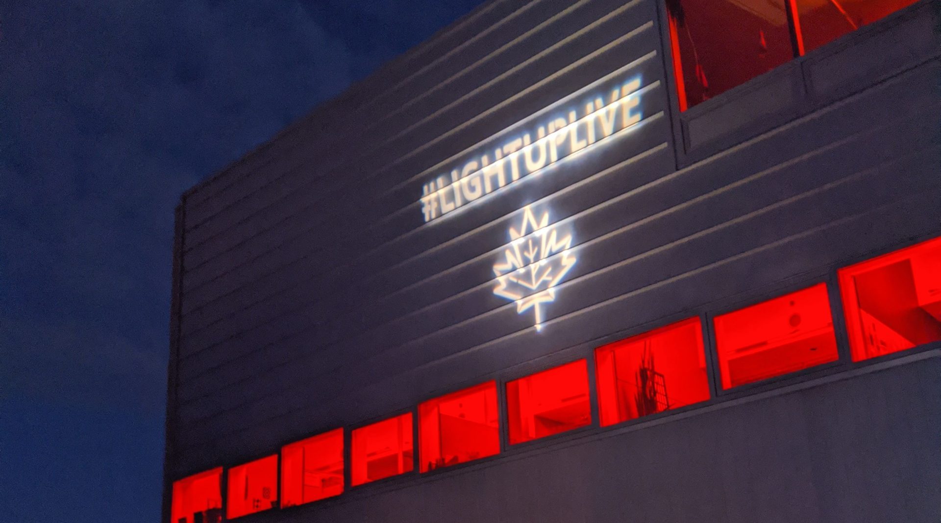 A building with red lights, and the LightUpLive logo