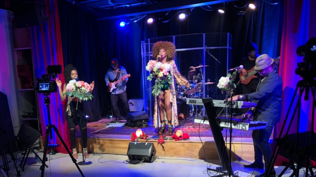 Prestation de l'artiste jamaïcaine-canadienne Ammoye accompagnée de cinq musiciens. Le tout est capté par des caméras.