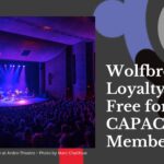A grey banner - on the left is a picture of a band performing onstage, bathed in blue and purple light. On the right is the text "Wolfbrown’s Loyalty Labs Free for CAPACOA Members."