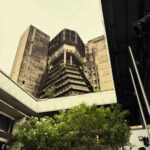 In the commercial heart of Abidjan (Le Plateau district), an MC announces the next MASA event in the courtyard of the Institut Français de Côte d'Ivoire - a key example of post-independence Tropical Brutalism. Raw exposed concrete sunshades and bold geometric volumes were characteristic of 1970s public architecture in West Africa.