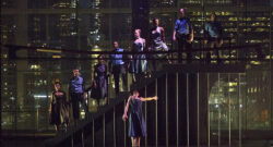 Un groupe de danseurs se tenant debout sur un escalier dans le noir.