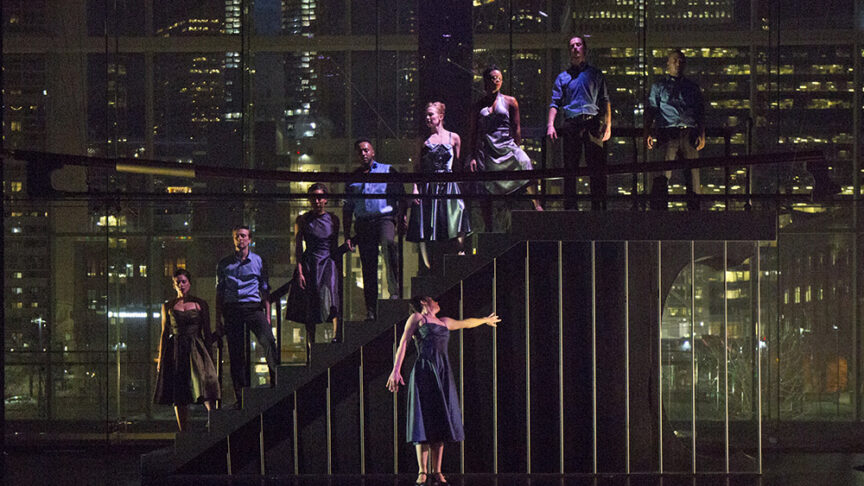 Un groupe de danseurs se tenant debout sur un escalier dans le noir.