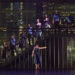A group of dancers standing on a staircase on a dark stage.